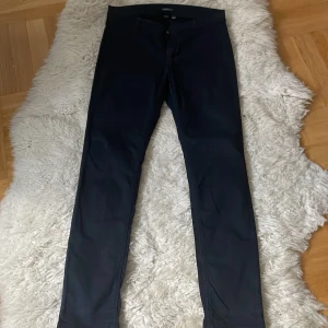 Svarta byxor från Esprit st.40 - Snygga svarta denim byxor från Esprit i en stilren design. Byxorna har en knapp och dragkedja framtill och är tillverkade i denim material som ger en bekväm passform. Midjemått 88 cm.Perfekta för en elegant look.