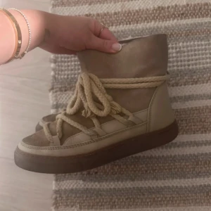 Boots från Inuikii - Säljer ett par snygga Boots från Inuikii med snörning och en robust sula. De är fodrade för extra värme och komfort. Perfekta för kyligare dagar.