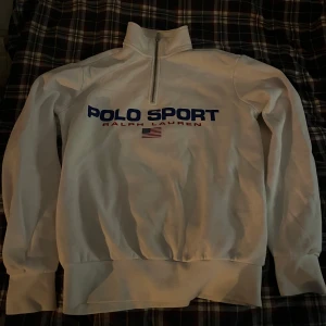 Vit halfzip från Ralph Lauren - Säljer denna riktigt fräscha Ralph lauren half zip. Den är i bra skick och har inga defekter. Det är storlek S men kan passa XS också.