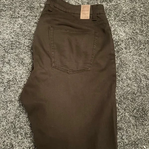 Bruna byxor från Hansen & Jacob - Snygga bruna byxor från Hansen & Jacob med en klassisk design. Byxorna har en bakficka och ett stilrent märke på baksidan. Perfekta för en stilren look. Byxorna är använda en gång och är i ett väldigt bra skick!
