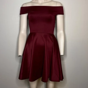 Vinröd offshoulder klänning från Boohoo - Vinröd offshoulder klänning från Boohoo. Smickrande passform med en kort kjol som ger en fin siluett. Tillverkad i ett mjukt och stretchigt material.