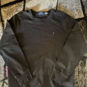 Ralph Lauren sweater  - Säljer en svart sweater från Ralph Lauren. Denna tröjan är använd bara en gång och den är mycket snygg som passar med allt. Den är i storlek M. Vid några funderingar är det bara att kontakta mig