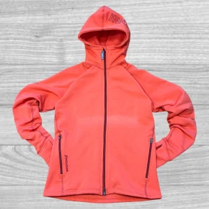 Houdini kofta - Säljer en snygg orange fleecejacka från Houdini med dragkedja och huva. Jackan har två praktiska fickor med dragkedjor och en stilren design. Perfekt för kyliga dagar!