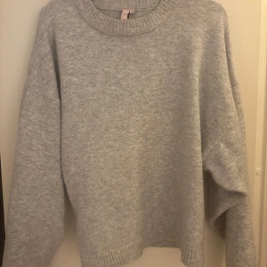 Grå stickad tröja från NELLY - Mysig grå stickad tröja med rund halsringning och långa ärmar. Perfekt för kyliga dagar och enkel att matcha med olika outfits. Tröjan har ribbade muddar vid ärmslut och nederkant för extra komfort. Rekommenderar verkligen till att ha med jeans eller till och med långa kjolar. Säljer för 280 kr men priset kan diskuteras❤️