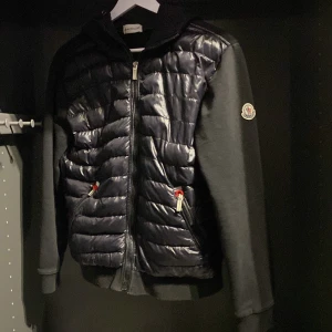 Svart moncler cardigan  - En svart moncler cardigan. Helt nytt skick förutom två små skador (se bild 4 och 5). Riktigt snygg.