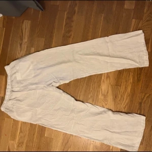 Vita linnebyxor - Snygga vita linnebyxor med en avslappnad passform. Perfekta för varma dagar med sitt lätta och luftiga material. Byxorna har en rak och vid stil som ger en skön känsla.