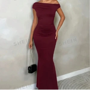 Vinröd långklänning från Shein - Elegant vinröd långklänning från Shein med offshoulder-design och öppen rygg. Klänningen har en figurnära passform som framhäver silhuetten. Perfekt för speciella tillfällen. Använt den 1 gång i några timmar. 