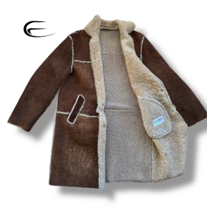 Brun skinnkappa från Dolce & Gabbana - Säljer en elegant brun skinnkappa från Dolce & Gabbana med mjukt foder. Kappan har en klassisk design med knappar framtill och två fickor. Perfekt för kyliga dagar när du vill hålla stilen. Storlek (s/m). David Beckham hade på sig en sådan jacka, kan demonstrera bilder 😉