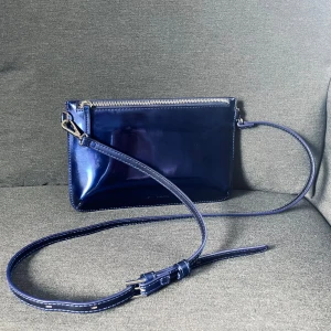 Carin Wester metallicblå axel-/kuvertväska - Metallblå axelremsväska, går att putsa upp helt glansig om så önskas med lite olja. 26x17cm. Superfint skick.