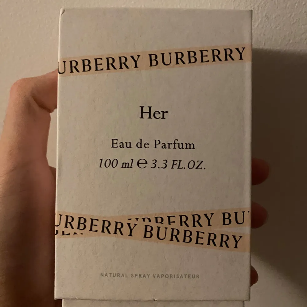 Säljer en lyxig Burberry Her Eau de Parfum i en elegant 100 ml flaska. Parfymen har en stilren design med en genomskinlig glasflaska och en ljusrosa kork. Doften är perfekt för den som vill ha en sofistikerad och modern touch. Flaskan är nästan full och kommer i sin originalförpackning.. Parfym.