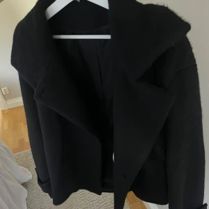 Arket kappa  - Svart kappa från arket, ”jacka i luddig ullblandning”. Strl: S, använd 3 ggr  Nypris: 1890kr Mitt pris: 990kr