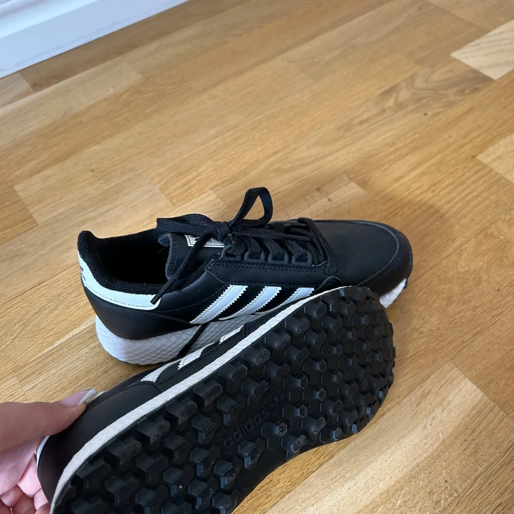 Svarta Adidas sneakers. Helt nya med etikett.  Storlek 38, mindre i storlek. Passar 37.. Skor.