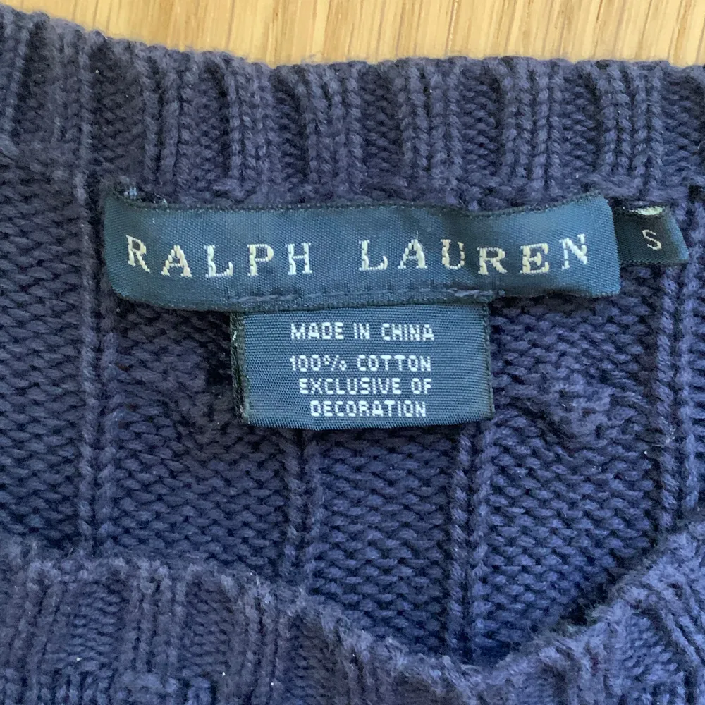 Mörkblå kabelstickad tröja från Ralph Lauren. Tröjan är i 100% bomull och använd ett fåtal gånger.. Tröjor & Koftor.