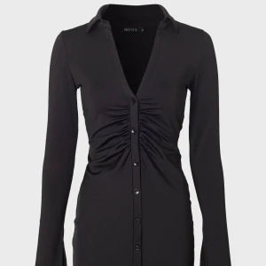 Svart rynkad klänning  - Svart rynkad klänning med knappar från Nelly 120kr