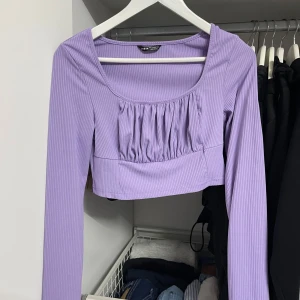 Lila ribbad topp från Shein - Säljer en superfin lila ribbad topp från Shein. Den har långa ärmar och en snygg croppad design med rynkdetaljer framtill. Perfekt för både vardag och fest! 💜