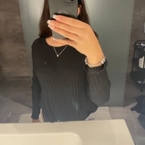 Svart tröja med slits, aldrig använd  - Mjuk, lätt att ta på sig.