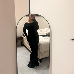 Svart offshoulder långklänning - Säljer en svart långklänning med offshoulder-design. Klänningen är ribbad och har en slits i bak. Den har en öppen rygg💕