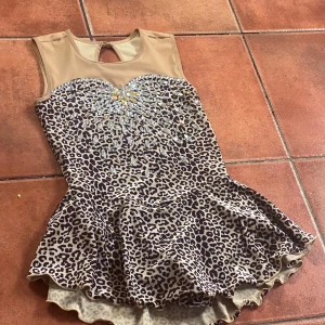 Leopard färgad konståknings klänning  - Leopard färgad konståknings klänning, super fin! Står ingen storlek på klänningen men jag är 1m 58cm och den är för kort för mig💗(kom privat om man vill ha mer info om storleken)💗 Kristaller på både rygg och bröst💗