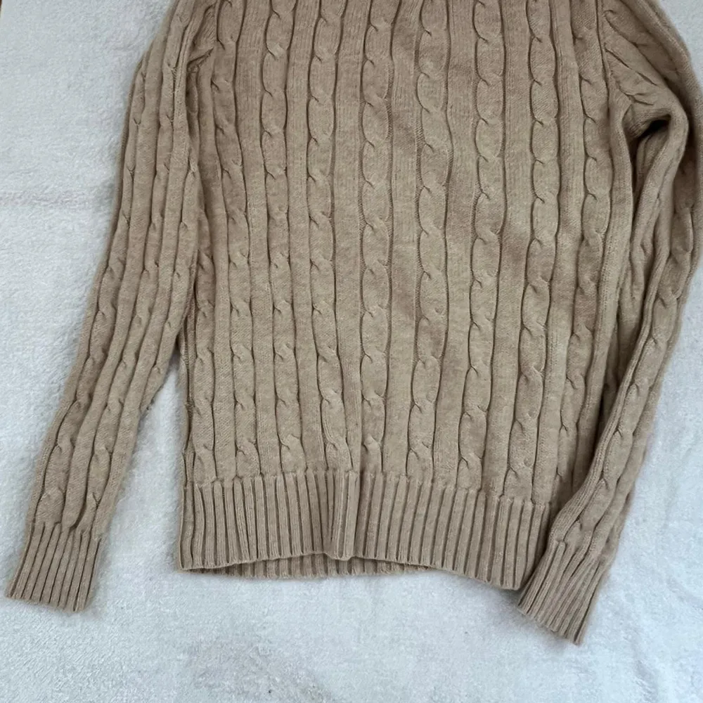 Säljer en superfin beige stickad tröja från Polo Ralph Lauren. Den har ett klassiskt flätmönster och är i storlek XS. Perfekt för höst och vinter med sina långa ärmar och mjuka material. Tröjan är i bra skick och redo för nya äventyr! 🍂✨. Tröjor & Koftor.