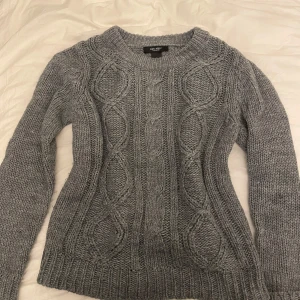 Grå stickad tröja från Express - Säljer en supermysig grå stickad tröja. Perfekt för kyliga dagar. Tröjan är långärmad och har en normal passform. Perfekt för höst och vinter!