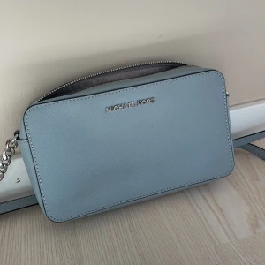 Michael Kors väska  - Väska från Michael Kors modellen JET SET TRAVEL CROSSBODY. Nypris är cirka 1 300kr. I princip oanvänd. 