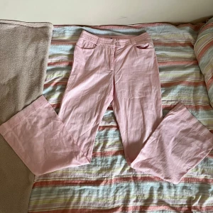 Rosa utsvängda jeans - Ljusrosa jeans/kostymbyxor med låg midja och bootcut!🩷 Dessa är tyvärr för små och har en liten defekt i knäppet som ska gå enkelt att laga! 