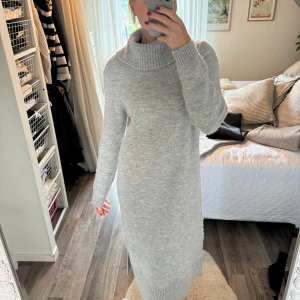 Stickad klänning  - Stickad klänning i midimodell, lite nopprig på ärmarna 