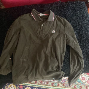Moncler tröja - Otroligt fet mörkgrön lång ärmad pike från moncler. Bra skick 100% äkta säljer för den inte passar längre