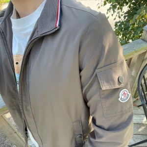 Moncler Windbreaker - Svin snygg windbreaker från moncler som  också tål regn. Den har två knapp fickor och en ostängbar inneficka. scan funkar. Den är storlek M men passar S.  Säljer den eftersom jag inte använder den längre. Om intresserad tveka inte på att höra av dig.