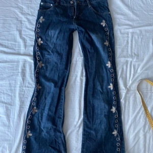 Lågmidjade jeans - Jeans med sydda detaljer, typ aldrig använda  Midja- 36,5 cm  Innerbenslängd- 74 cm