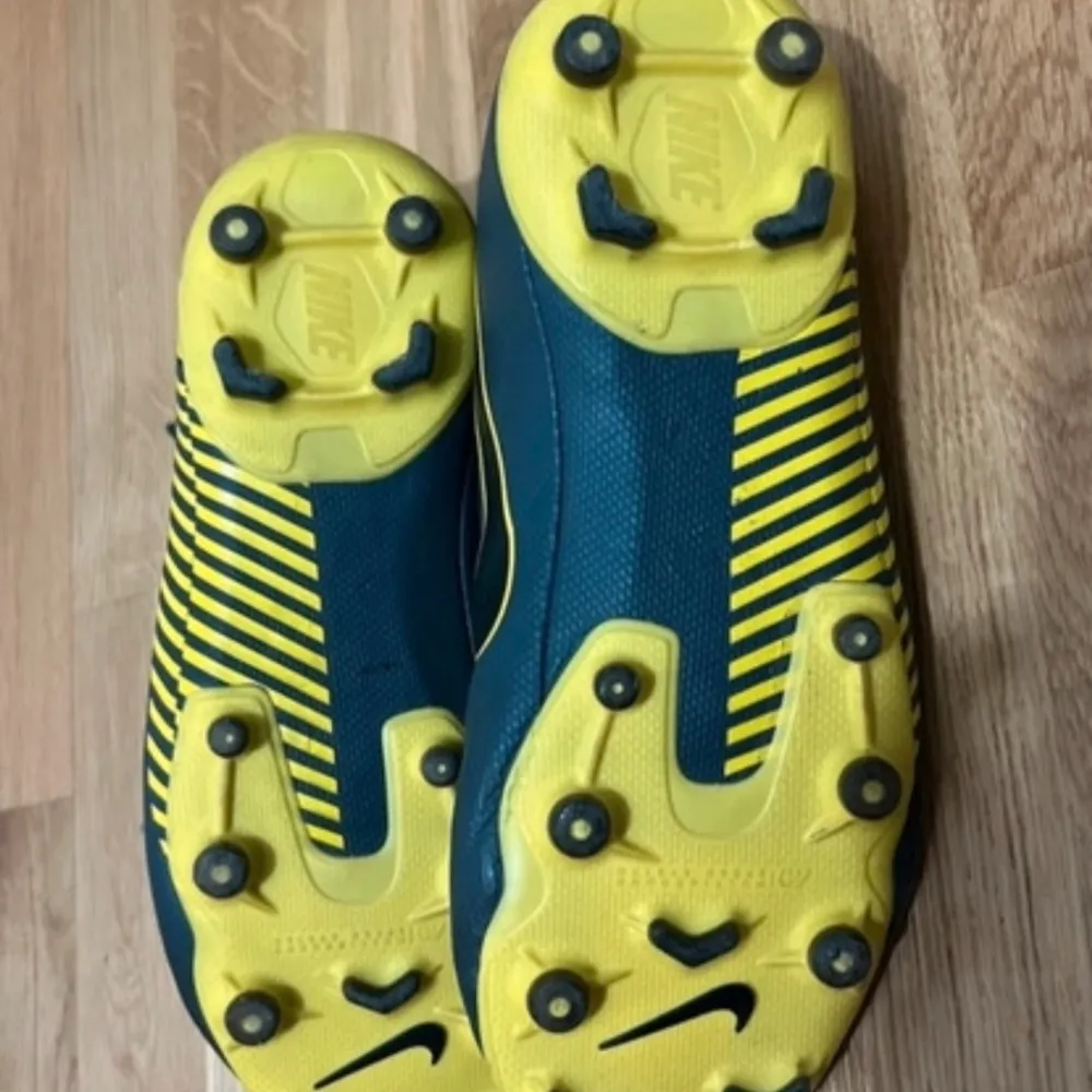 Ett par Nike fotbollsskor i mycket bra skick med mycket bra kvalité. De är fräscha, rena och bekväma. Färg: gul och grå Strl: 38,5. Kengät.