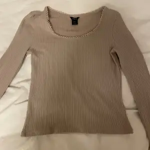 En fin beige tröja från Lindex i storlek M men passar nog S också eftersom den är ganska liten i storleken. Den har lite mönster runt halsen och längst ner vid ärmarna💗