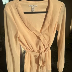 Söt blus - Söt beige blus med knyte med v-ringning.