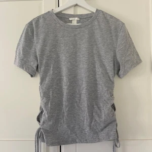 Grå t-shirt med knytningar💗 - Snygg grå t-shirt med knytningar på sidorna.💗 Knappt använd.💞