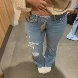 Säljer dessa nya Levis jeansen med hål. Modellen är Superlow boot, storlek 25. (första bilden är lånad men de är samma modell) Tvättade och använda en gång då dom inte passade mig. Midjemått 35 cm, Innerbenslängden 76 cm.