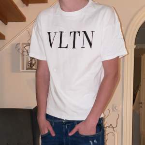 Säljer en snygg vit t-shirt från Valentino med VLTN-tryck i svart. Den är i nytt skick och har en normal passform. Perfekt för både vardag och fest! T-shirten är i storlek XS/S och priset är lågt pga att det kommit lite färg på höger axel men syns knappt om man inte tittar noga! T-shirten är köpt ifrån Valentino’s original hemsida. Skriv gärna vid intresse❤️🙌