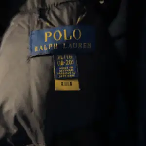 Säljer en svart dunjacka från Polo Ralph Lauren i storlek XS Jackan är perfekt för kalla vinterdagar med sin tjocka vaddering och stilrena design. Den har en dragkedja framtill och flera praktiska fickor. Passar både till vardags och mer uppklädda tillfällen. Kom dm för fler bilder, kan gå ner lite i pris vid snabb affär