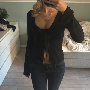 Svart långärmad knytblus - Snygg svart långärmad blus med knytning framtill från Gina . Perfekt för både vardag och fest. Använd fåtal gånger så inga defekter🖤storlek S men skulle även passa nån som bär xs/s/m