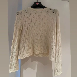 Beige/vit stickad tröja - Säljer en superfin beige/vit stickad tröja med ett snyggt hålmönster. Den är perfekt för både höst och vår och har långa ärmar. Tröjan är i mycket bra skick och passar perfekt till ett par jeans eller kjol. Perfekt för en mysig dag ute eller hemma! 🍂