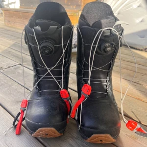 Svarta snowboardboots från Burton - Säljer ett par svarta Burton Photon BOA snowboardboots i mycket bra skick. De har en smidig snörning med BOA-system. Storlek 42 EU.