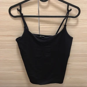 Svart linnetopp från Gina Tricot stl M - Säljer en svart linnetopp från Gina Tricot i storlek M. Toppen har smala axelband och är perfekt för sommardagar eller som ett basplagg i garderoben. Axelbanden är justerbara! I mycket fint skick!
