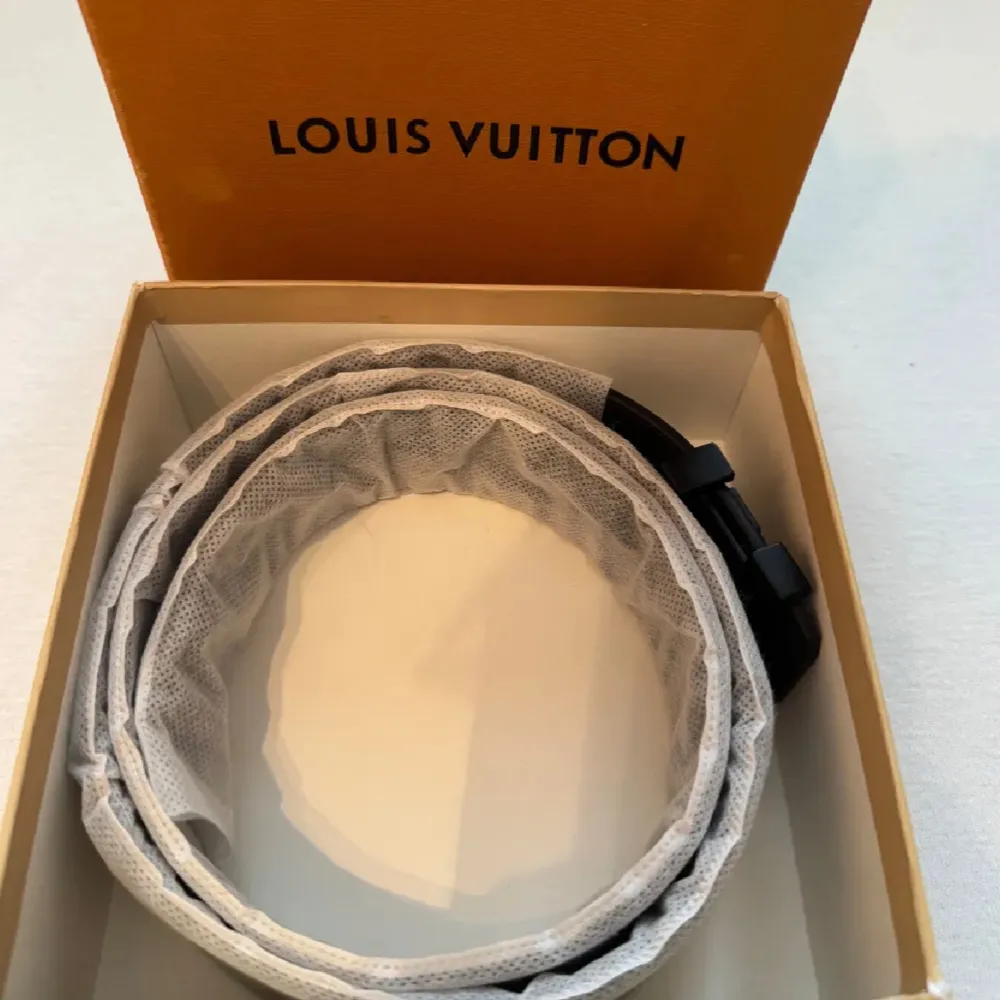 Säljer ett snyggt grått Louis Vuitton bälte i klassiskt rutigt mönster. Bältet har en stilren svart spänne med LV-loggan. Perfekt för att ge en lyxig touch till din outfit. Kommer i originalförpackning med kvitto. Passar både till vardag och fest! Det är oanvände och säljer billigt som vanligt . Övrigt.