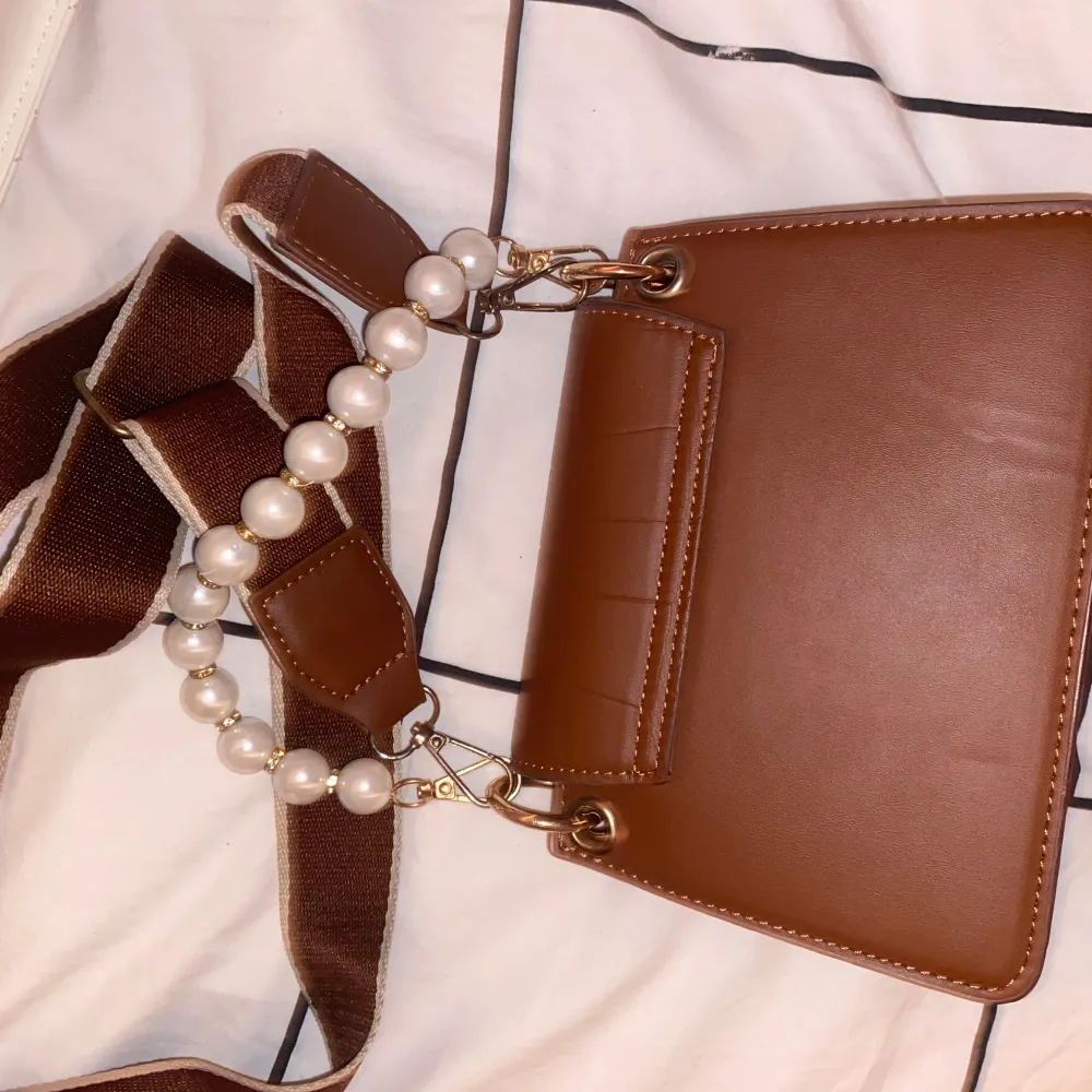 Säljer en superfin brun axelväska i syntetmaterial med krokodilmönster. Väskan har ett pärlhandtag och en justerbar axelrem i brunt tyg.👜✨ . Laukut & Käsilaukut.