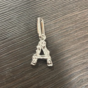 Silverfärgad berlock i form av bokstaven A - Snygg och stilren berlock i form av bokstaven A. Den är silverfärgad och har en detaljerad design med små mönster som ger en lyxig känsla. Perfekt att fästa på ett armband eller halsband för en personlig touch. Passar både till vardags och fest! Texturernat A, kommer i påsen/ paket som det var köpt i, köpt för 200kr, aldrig använd