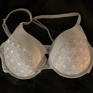 Grå spets-bh från Bella Bloom 75C - Säljer en grå bh från Bella Bloom i storlek 75C. Den har vacker spetsdetalj på kuporna och justerbara axelband. Aldrig använd