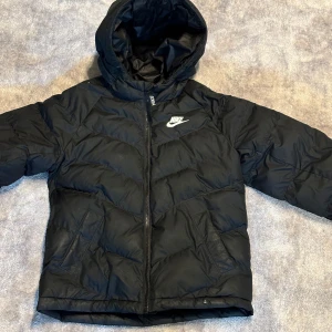 Vinterjacka - En väldigt bekväm och varm vinterjacka från Nike! Du kan ha den på hela vintern, men fungerar även på hösten. Skönt material som håller värmen bra! Storlek 146, men skulle säga att den passar någon som är runt 160 cm.