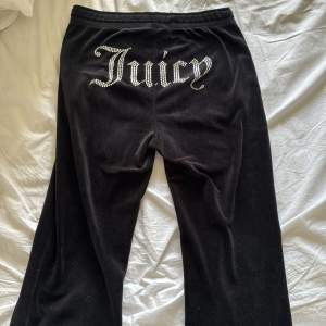 Säljer ett par svarta mjukisbyxor från Juicy Couture i mycket bra skick. Byxorna har en glittrig Juicy-logga på baksidan och snörning i midjan. Framtill så är en knapp av och ”hylsan” som sitter på snöret. Annars är dom i bra kvalite 