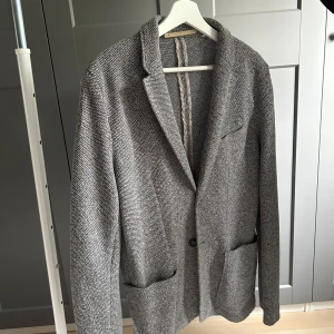 Ofodrad kavajjacka  - Ofodrad kavajjacka från Zara, perfekt att ha ovanför en stickad tröja nu när det blir lite kyligare. Väldigt smidig och bekväm pga ofodrad och stickat materia. Strl 46. Fint skick. 