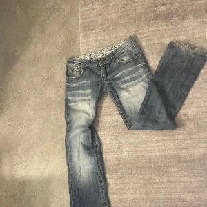 Lågmidjade bootcut jeans! - Säljer ett par snygga blå jeans i bra skick. De har en cool broderad detalj på bakfickorna och en klassisk femficksdesign. Jeansen är lågmidjade och är bootcut, perfekt för en avslappnad stil. De är tillverkade i slitstarkt denim och har en lätt tvättad look. Midjemåttet är kring 39 tvärs över, innerbenslängden är runt 78cm ish. 💕