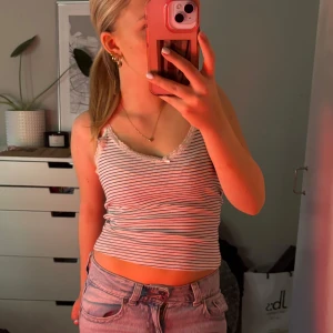 Randig linne från H&M - Säljer ett randigt linne från H&M i storlek S. Det är vitt med tunna svarta ränder och har en söt spetsdetalj vid halsringningen. Perfekt för sommardagar eller som ett lager under en tröja. Linnet är i bra skick och superbekvämt att bära.💞